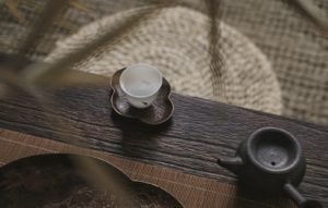 white teacup on saucer near teapot